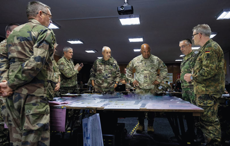 Senior officers standing around a map table planning an operation.