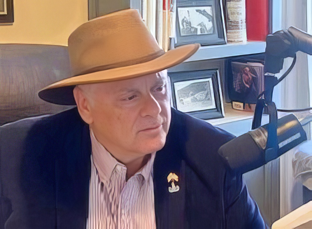 Mark Melrose recording an episode at his podcast microphone.